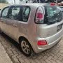 C3 Picasso prata estacionado em pátio automotivo.