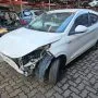 Argo branco estacionado em pátio automotivo.