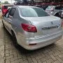 Traseira de um Peugeot 207 Passion cinza estacionado em pátio automotivo.