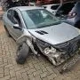 Frente de um Peugeot 207 Passion cinza estacionado em pátio automotivo.
