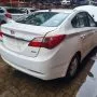 Traseira de um HB20 branco estacionado em pátio automotivo.