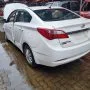 Traseira de um HB20 branco estacionado em pátio automotivo.