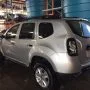 Renault Duster prata estacionado em pátio automotivo.