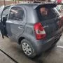 Etios cinza estacionado em pátio automotivo.