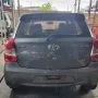Etios cinza estacionado em pátio automotivo.
