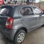 Etios cinza estacionado em pátio automotivo.