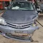 Etios cinza estacionado em pátio automotivo.