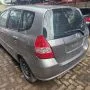 Fit cinza estacionado em pátio automotivo.