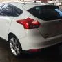 Ford Focus branco estacionado em pátio automotivo.