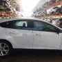 Ford Focus branco estacionado em pátio automotivo.