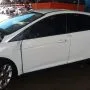 Ford Focus branco estacionado em pátio automotivo.