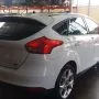 Ford Focus branco estacionado em pátio automotivo.