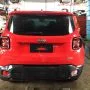 Traseira de um Jeep Renegade vermelho estacionado em pátio automotivo.