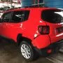 Traseira de um Jeep Renegade vermelho estacionado em pátio automotivo.