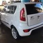 Traseira de um Kia Soul branco estacionado em pátio automotivo.