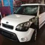 Frente de um Kia Soul branco estacionado em pátio automotivo.