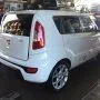Frente de um Kia Soul branco estacionado em pátio automotivo.