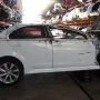 Lancer branco estacionado em pátio automotivo.