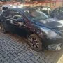 Nissan Versa preto estacionado em pátio automotivo.