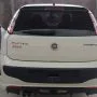 Traseira de um Punto branco estacionado em pátio automotivo.