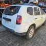 Renault Duster branco estacionado em pátio automotivo.
