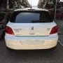 Traseira de um Peugeot 307 branco estacionado em pátio automotivo.