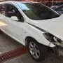 Frente de um Peugeot 307 branco estacionado em pátio automotivo.