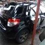 SX4 preto estacionado em pátio automotivo.